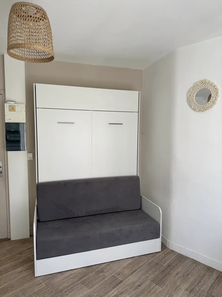 Das graue Sofa vor dem geschlossenen Wandbett