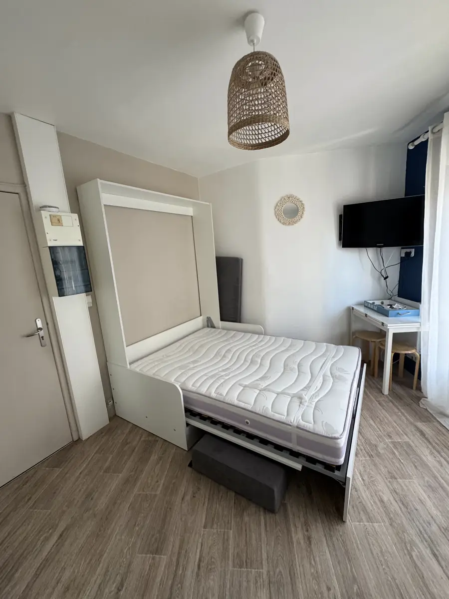 Das ausgeklappte Bett am Eingang, auf hellem Holzboden